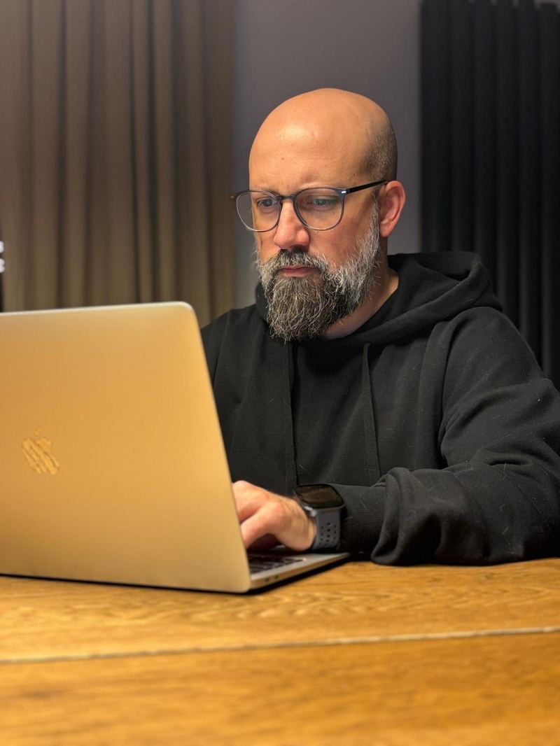 Sergio working on a laptop at a wooden table